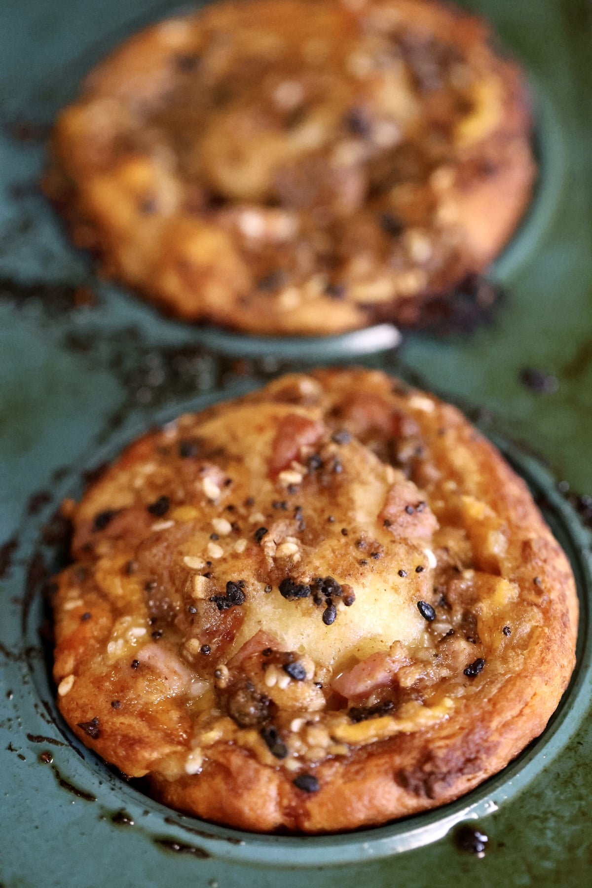 Ham and cheese muffin in a blue muffin pan.