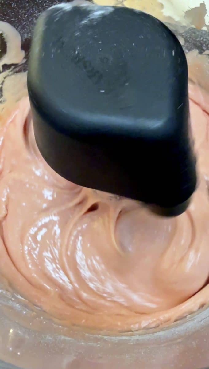 Strawberry cake mix batter in a mixer bowl.