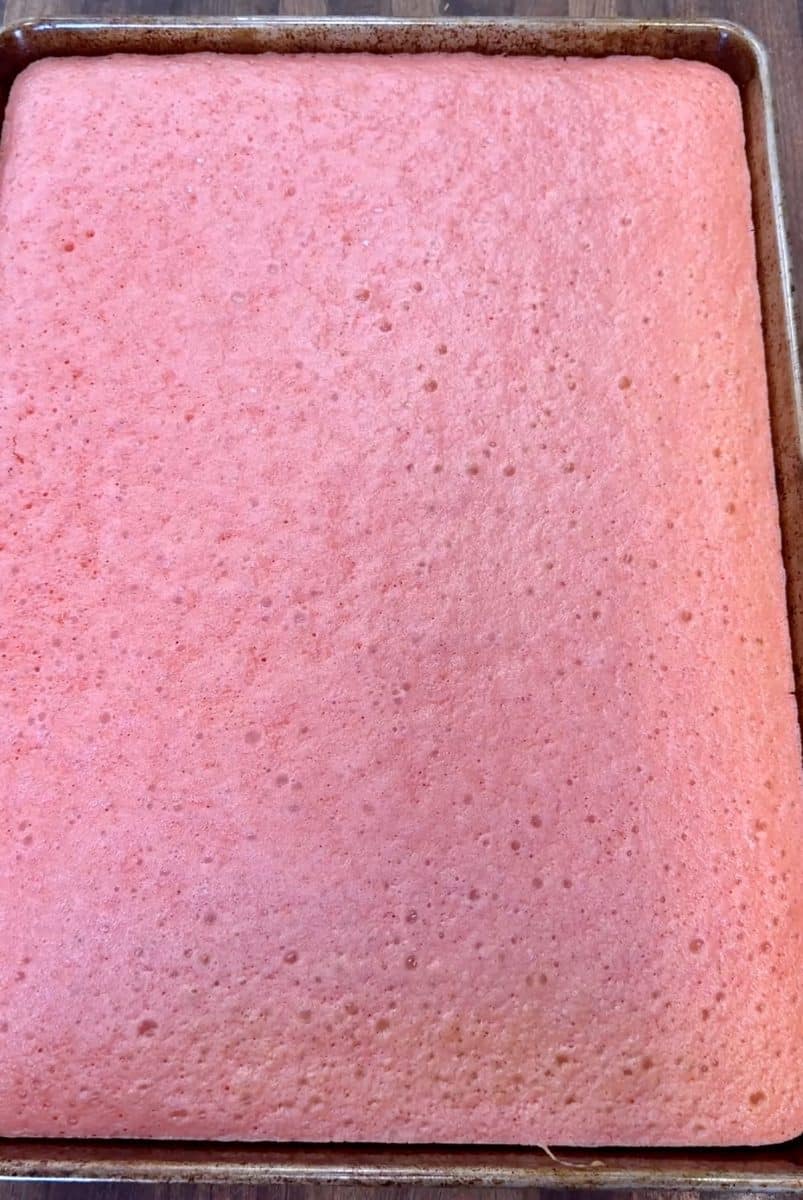 Strawberry cake baked in a half sheet pan.