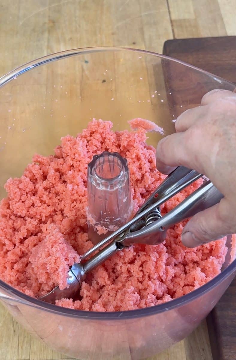 Scooping cake into a cake ball with cookie scoop.