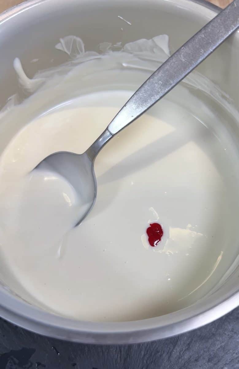 Melted white chocolate coating with red food coloring drops.