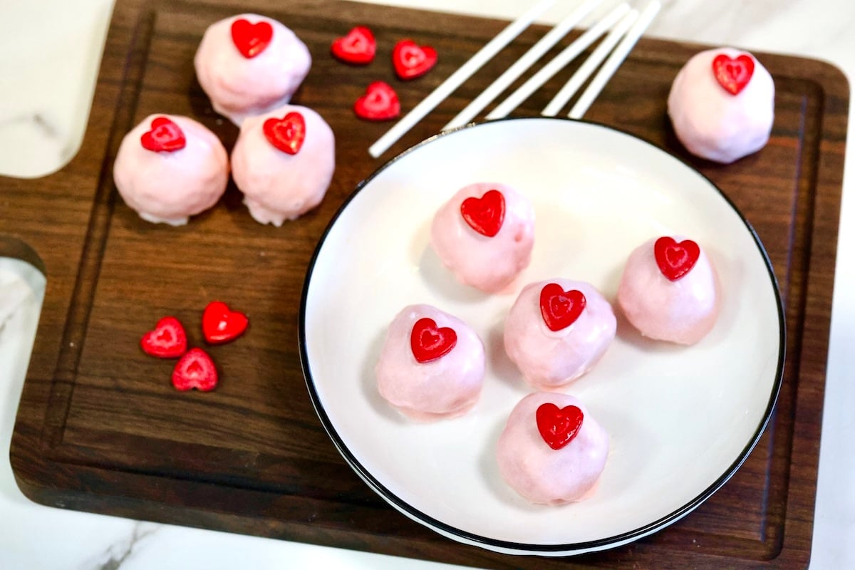 Strawberry cake balls with heart sprinkles.