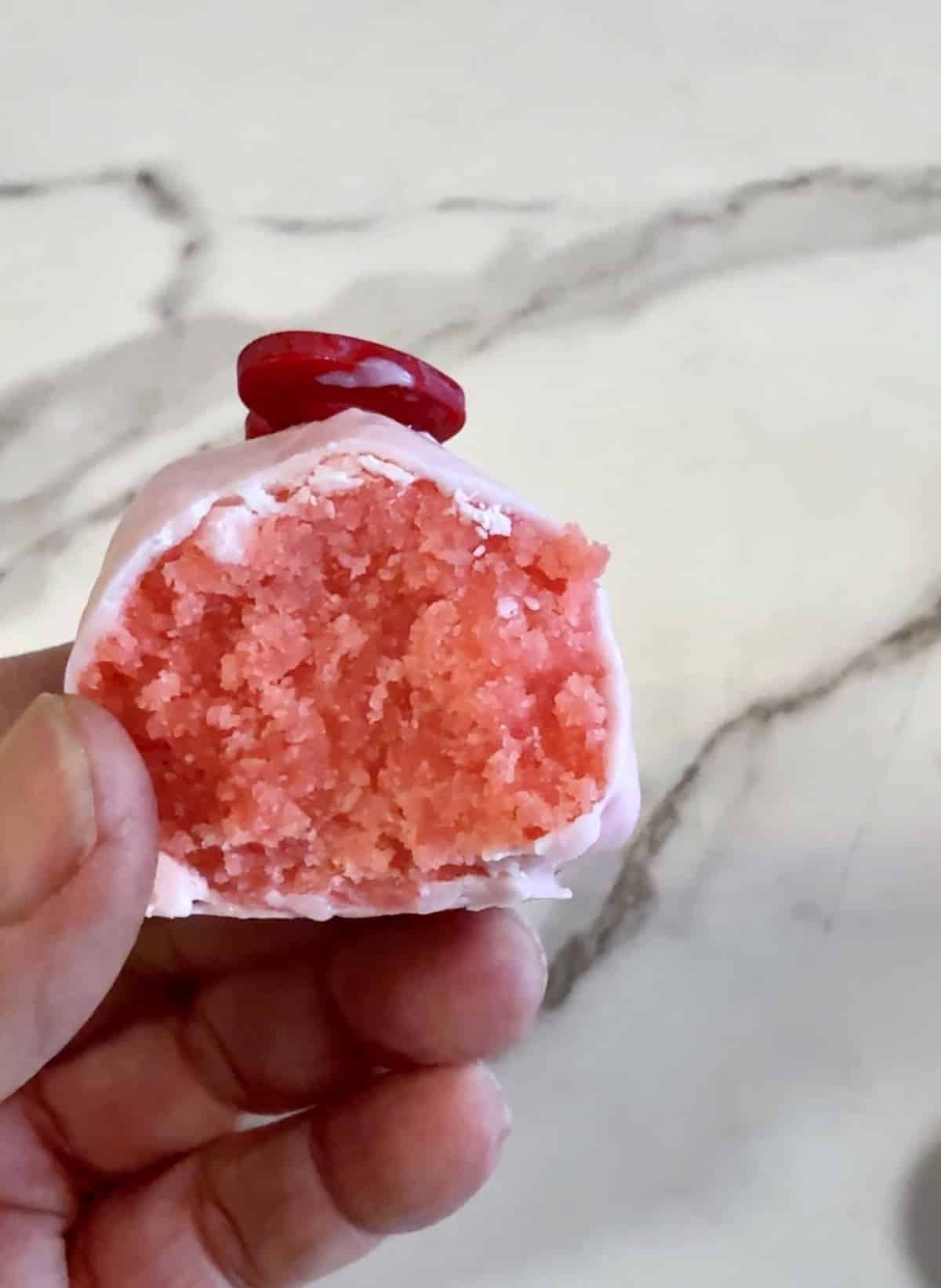 Strawberry cake ball with inside showing.