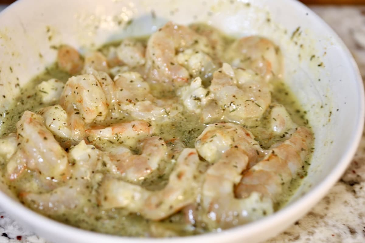 Marinating shrimp in Italian dressing in a bowl.