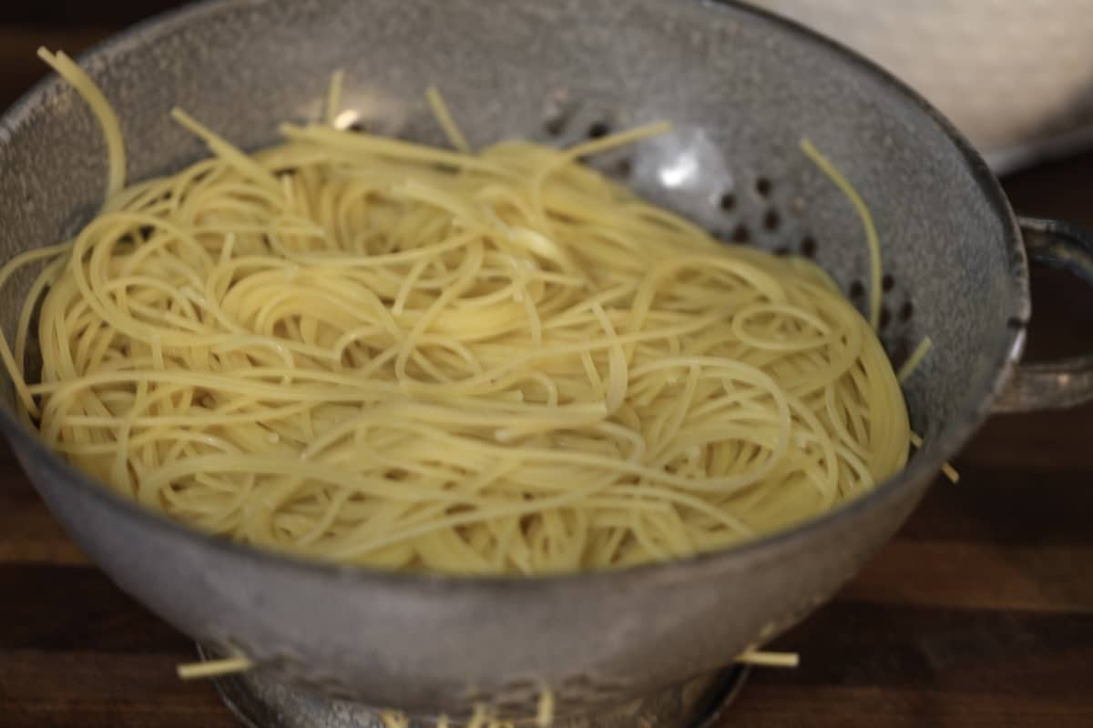 Spaghetti draining in a colander.