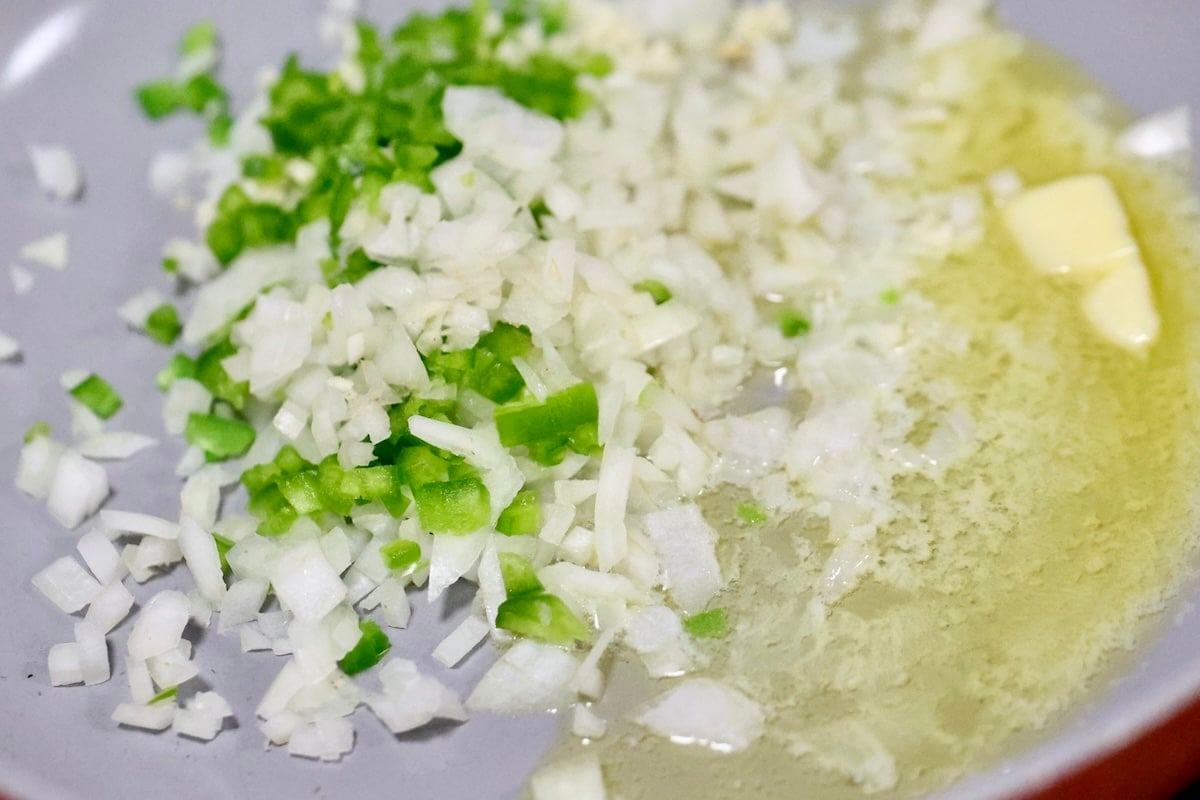 Cooking butter, onion and jalapeno in a pan.