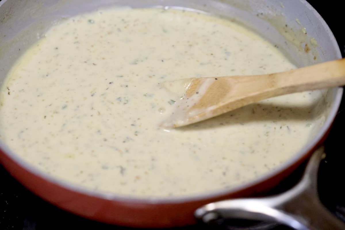 White queso in a pan with wooden spoon.