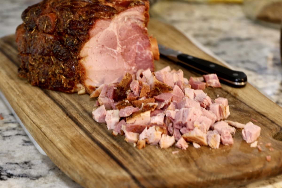 Holiday ham with chopped ham on a cutting board.