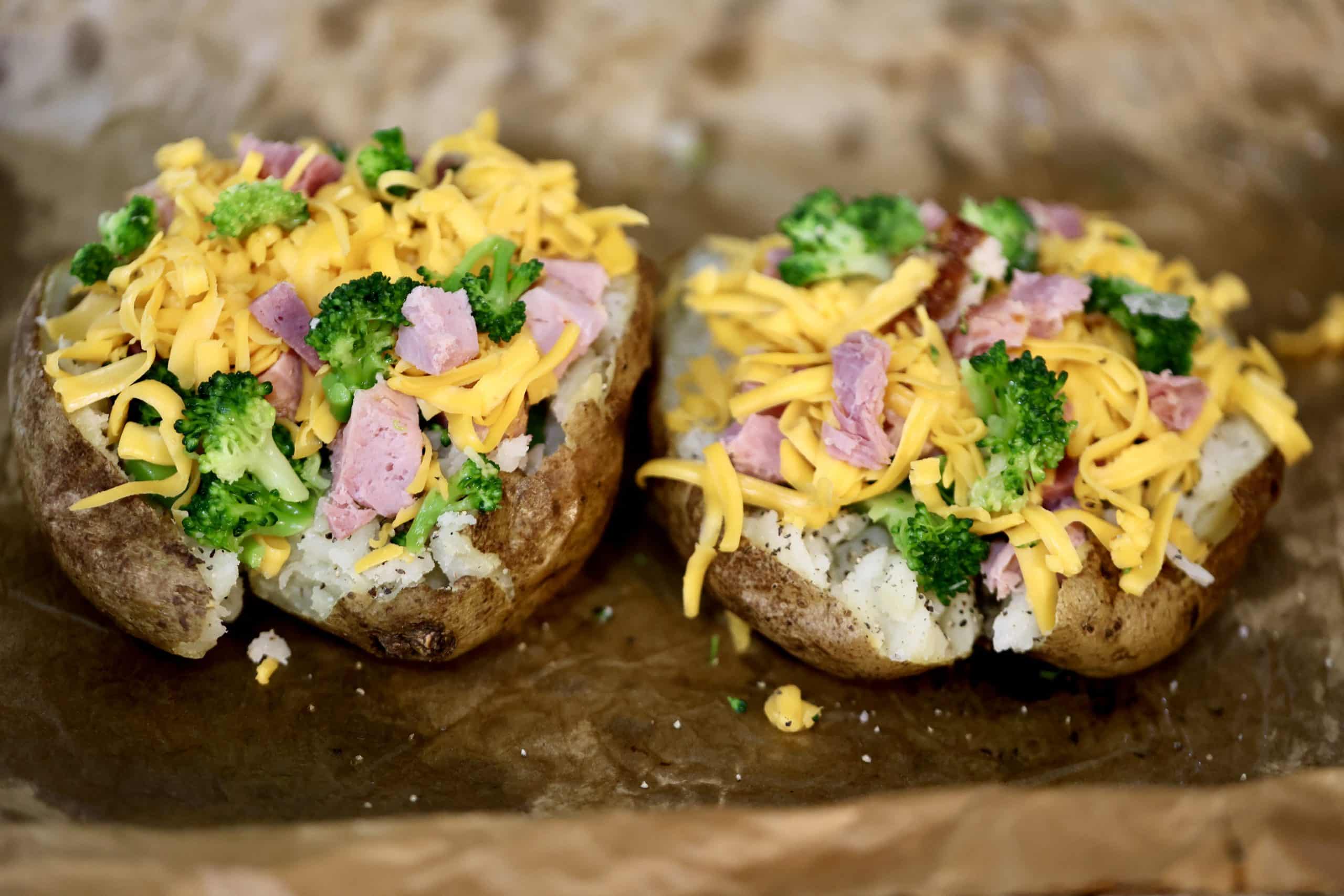 2 baked potatoes loaded with ham, broccoli and shredded cheddar.