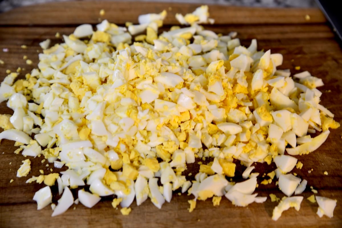 Chopped hard boiled eggs on a cutting board.