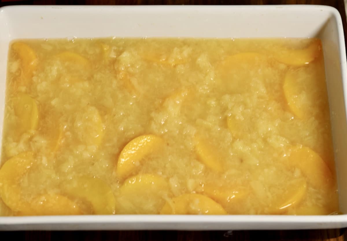 Sliced peaches and crushed pineapples in a 9 x 13 pan.