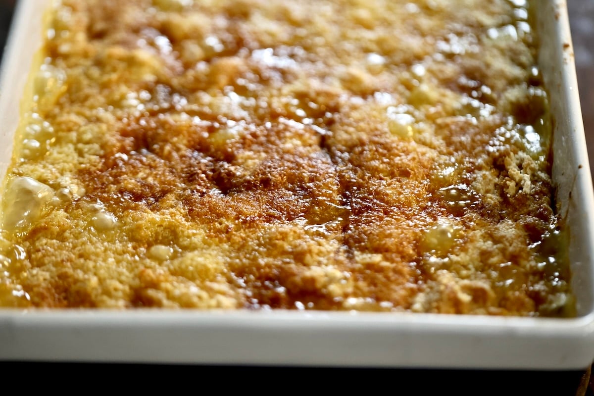Pineapple peach cake mix cobbler. Peach Pineapple Dump Cake in a baking dish.
