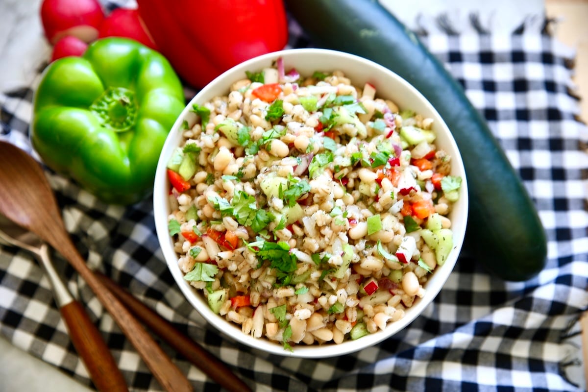 Bowl of white beans, barley, vegetable salad.