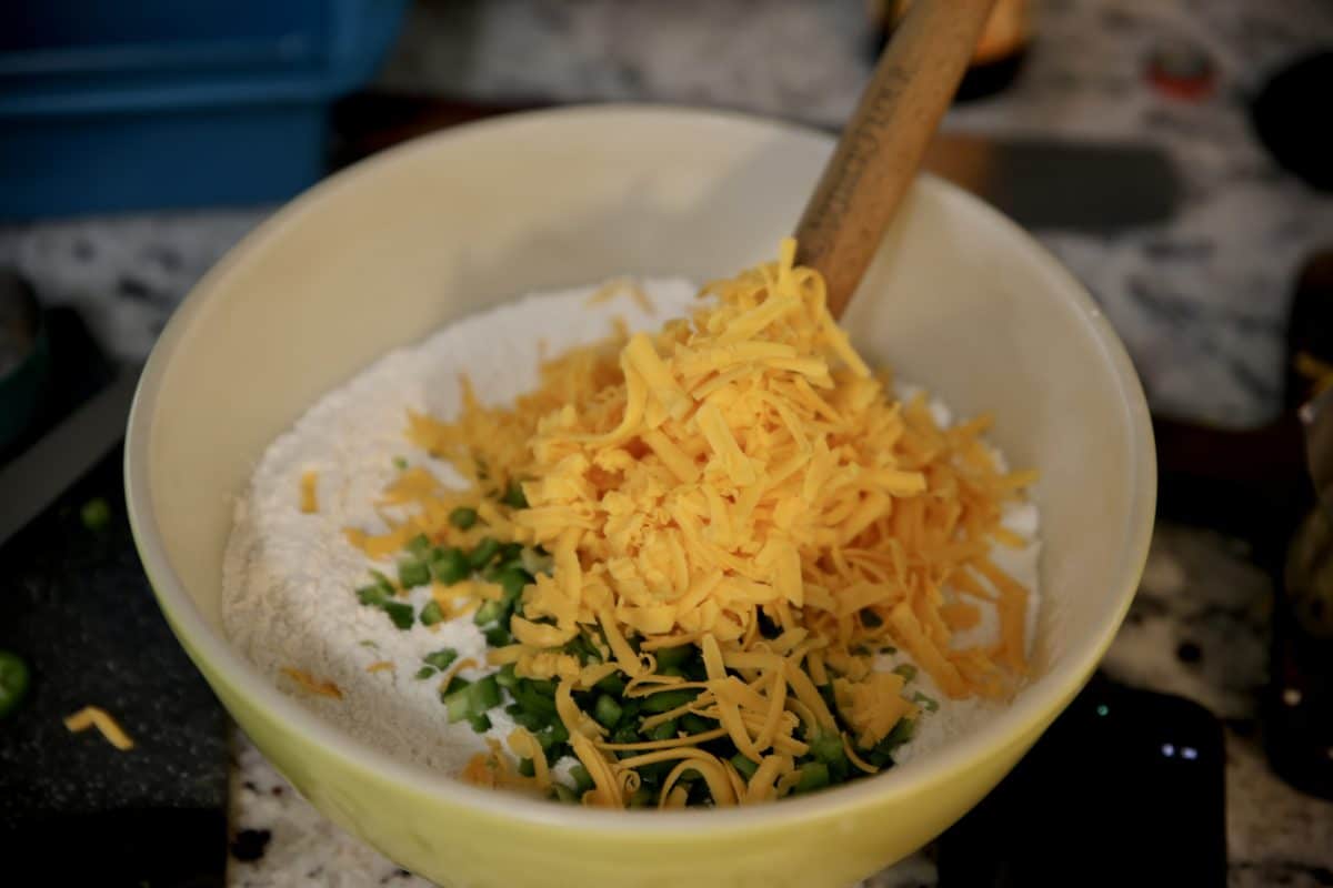 Jalapenos and cheddar cheese in a bowl with flour for bread.