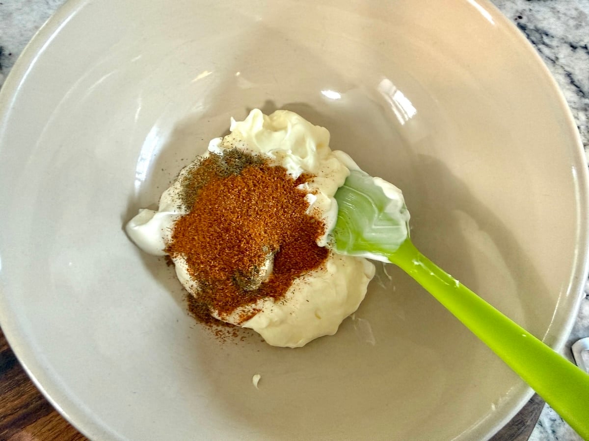 Mayo based dressing with seasonings in a bowl for seafood salad.
