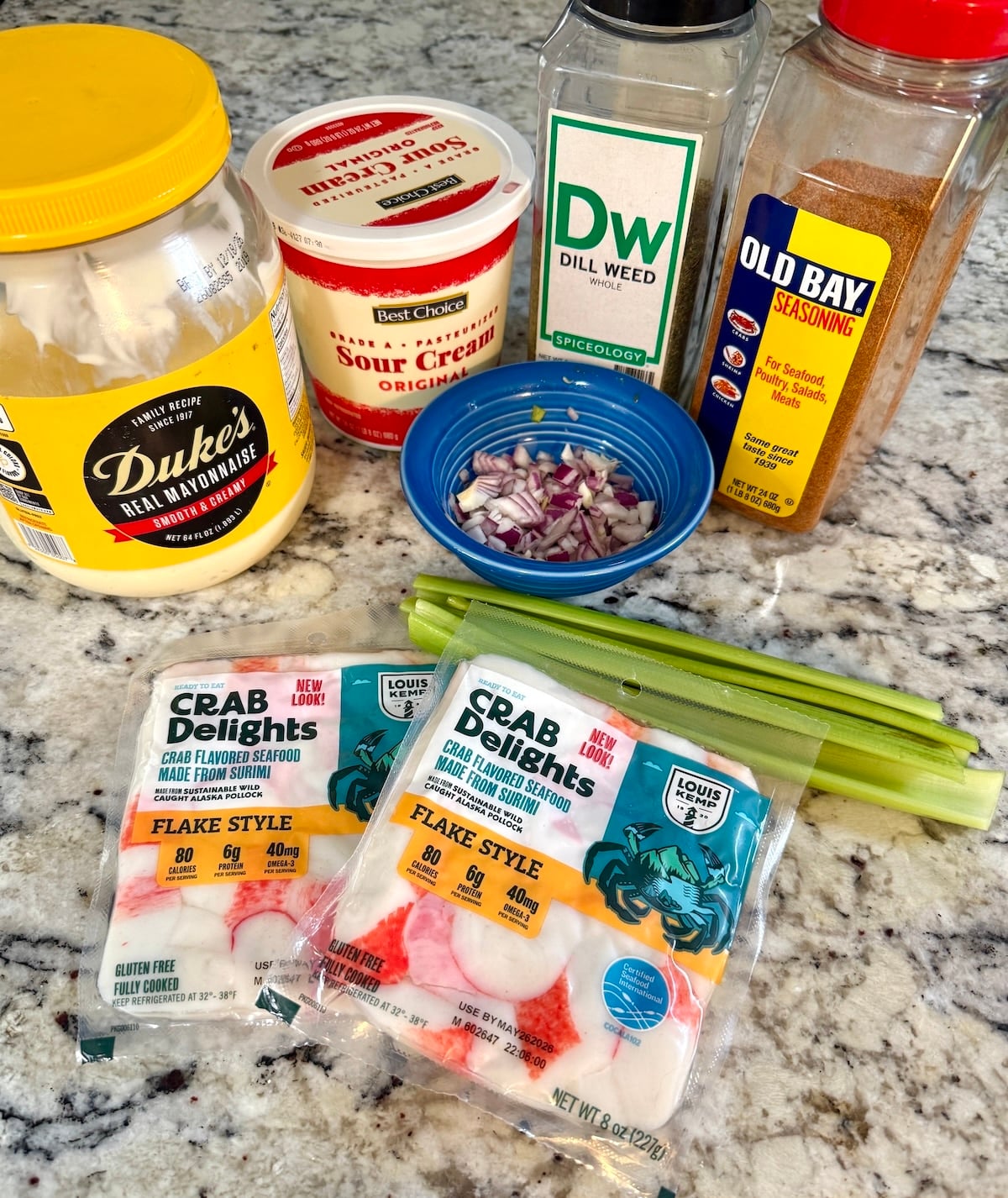 Ingredients for seafood salad, mayo, sour cream, imitation crab & seasonings.