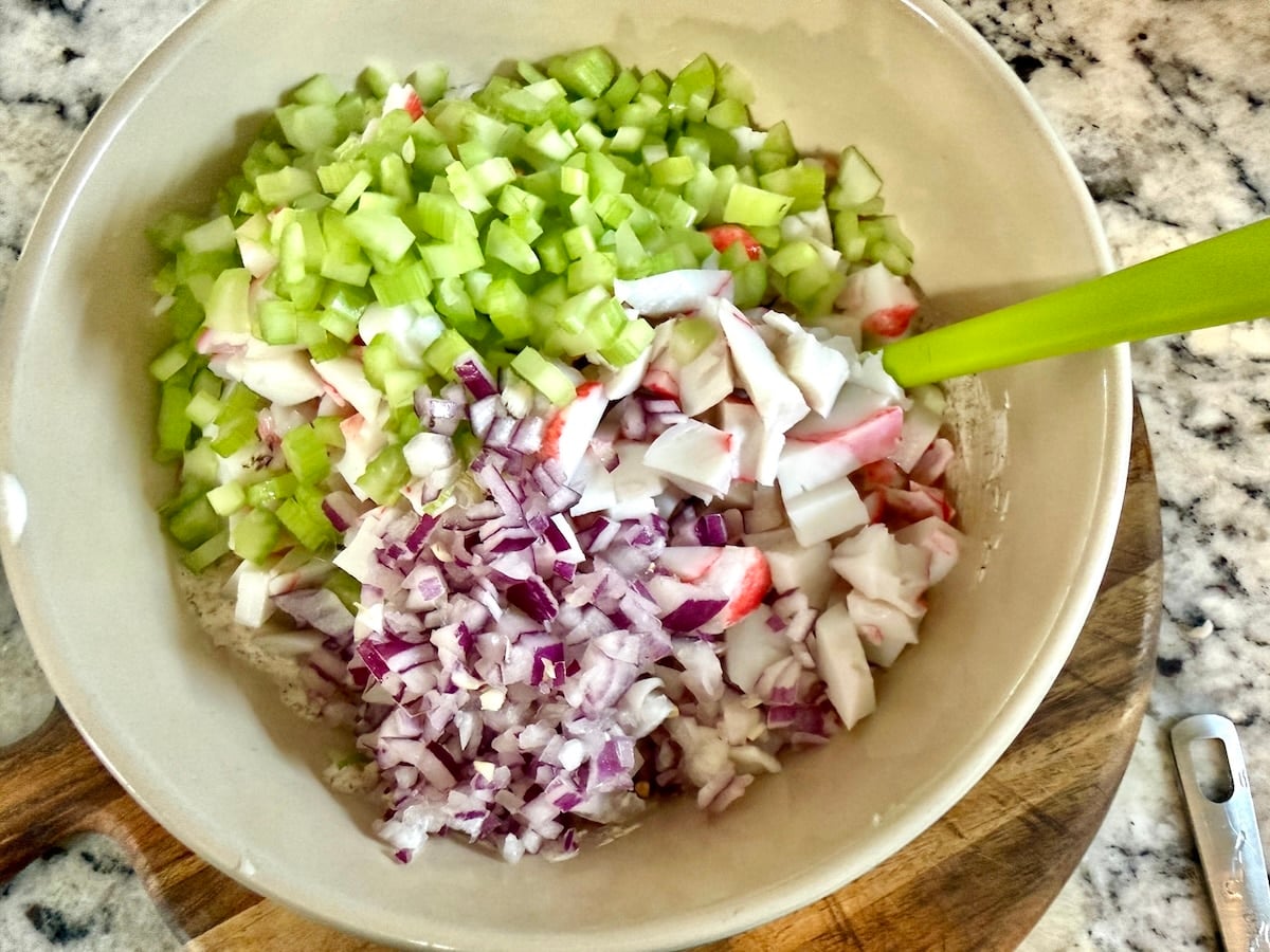 Imitation crab, celery, red onion in a bowl.