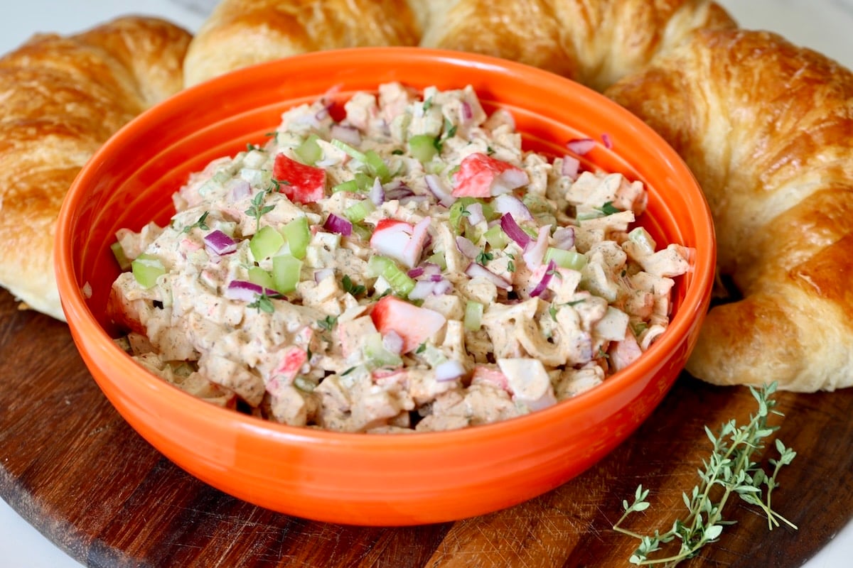 Bowl of seafood salad with croissants.