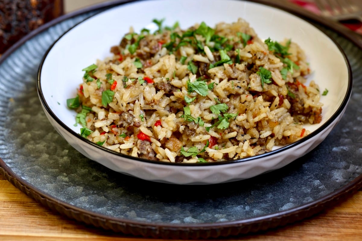 Dirty rice in a bowl on a plate.
