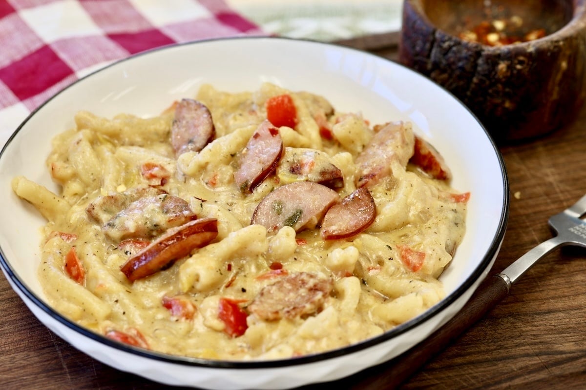 Bowl of smoked sausage pasta with bell peppers.